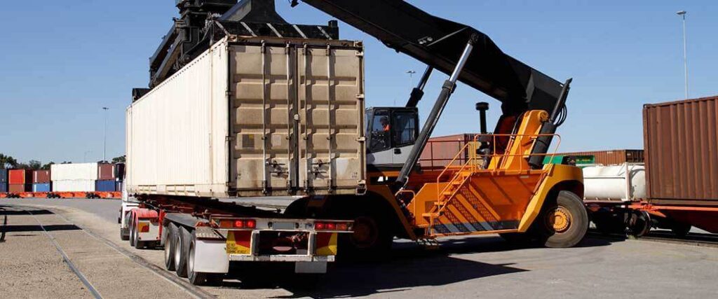 A transloading container is loaded onto a truck chassis
