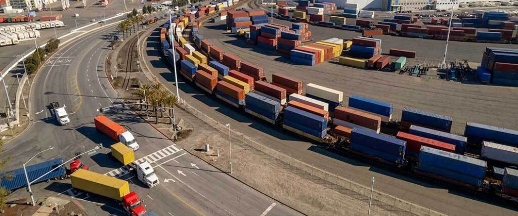 Transload containers on rails at a shipping terminal