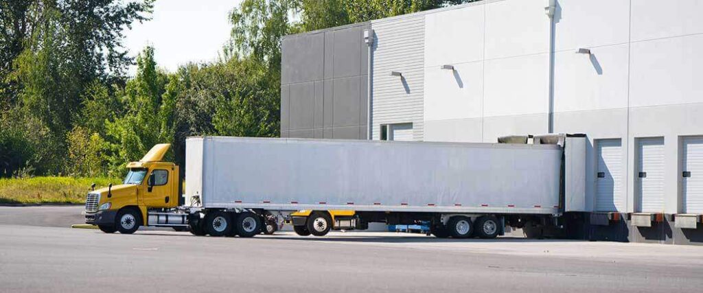 A semi truck outside a cross dock loading=