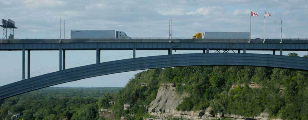 Semi trucks traveling over a Canadian bridge