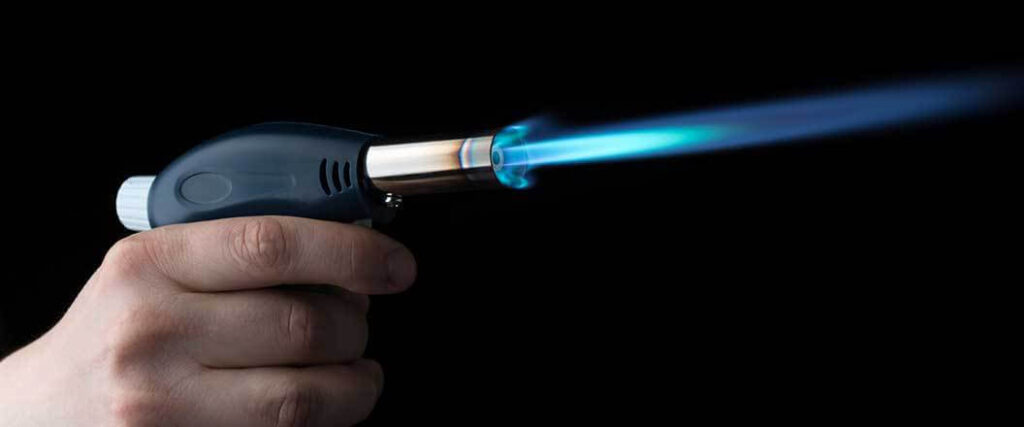 butane transloading hand holding a lit food torch