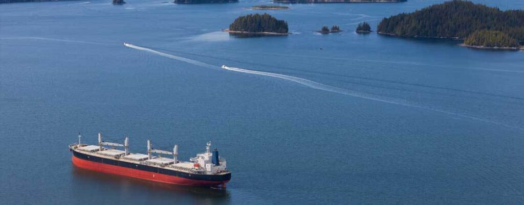 Aerial view of a dry bulk barge on a lake that's coming in to dock