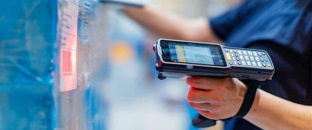 A warehouse worker scanning barcodes on freight