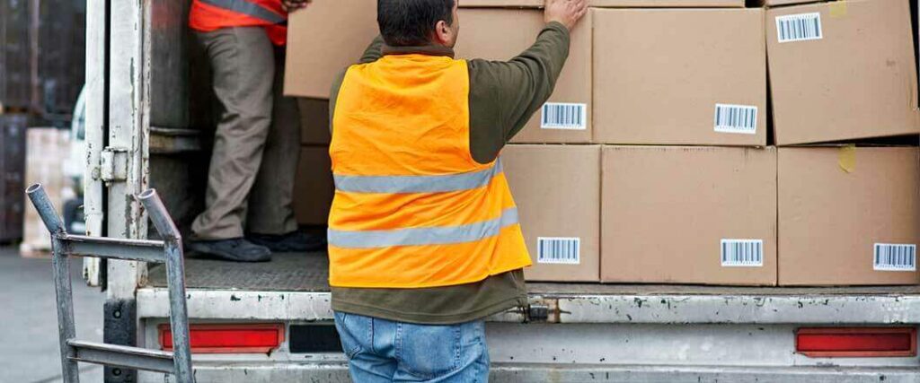 Workers in safety vests loading=